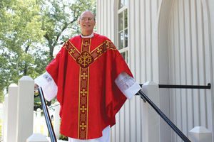 Dr. Hayes in red Pentecost vestments on the church steps