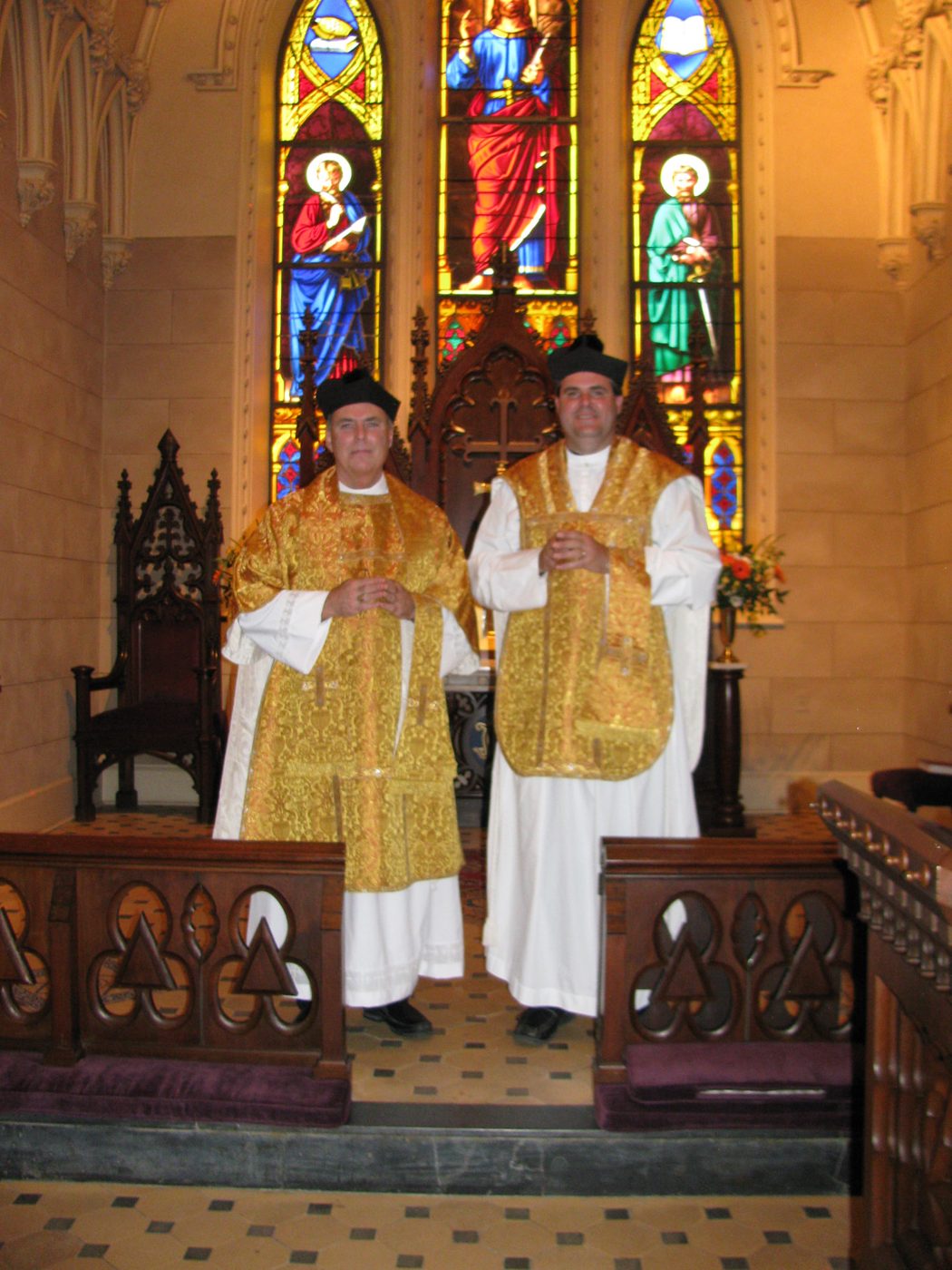 Dr. Hayes, vested for the Mass, in a chapel with stained-glass windows